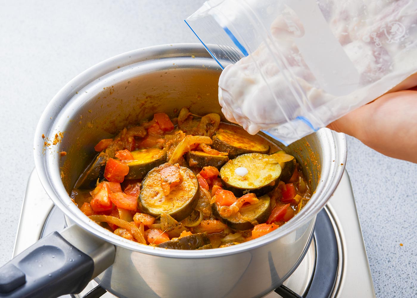 【3】にトマト、なす、【A】を入れて炒め、【1】をヨーグルトごと加える★。水を注ぎ、ふたをして弱火で約20分、鶏肉がやわらかくなるまで煮る。