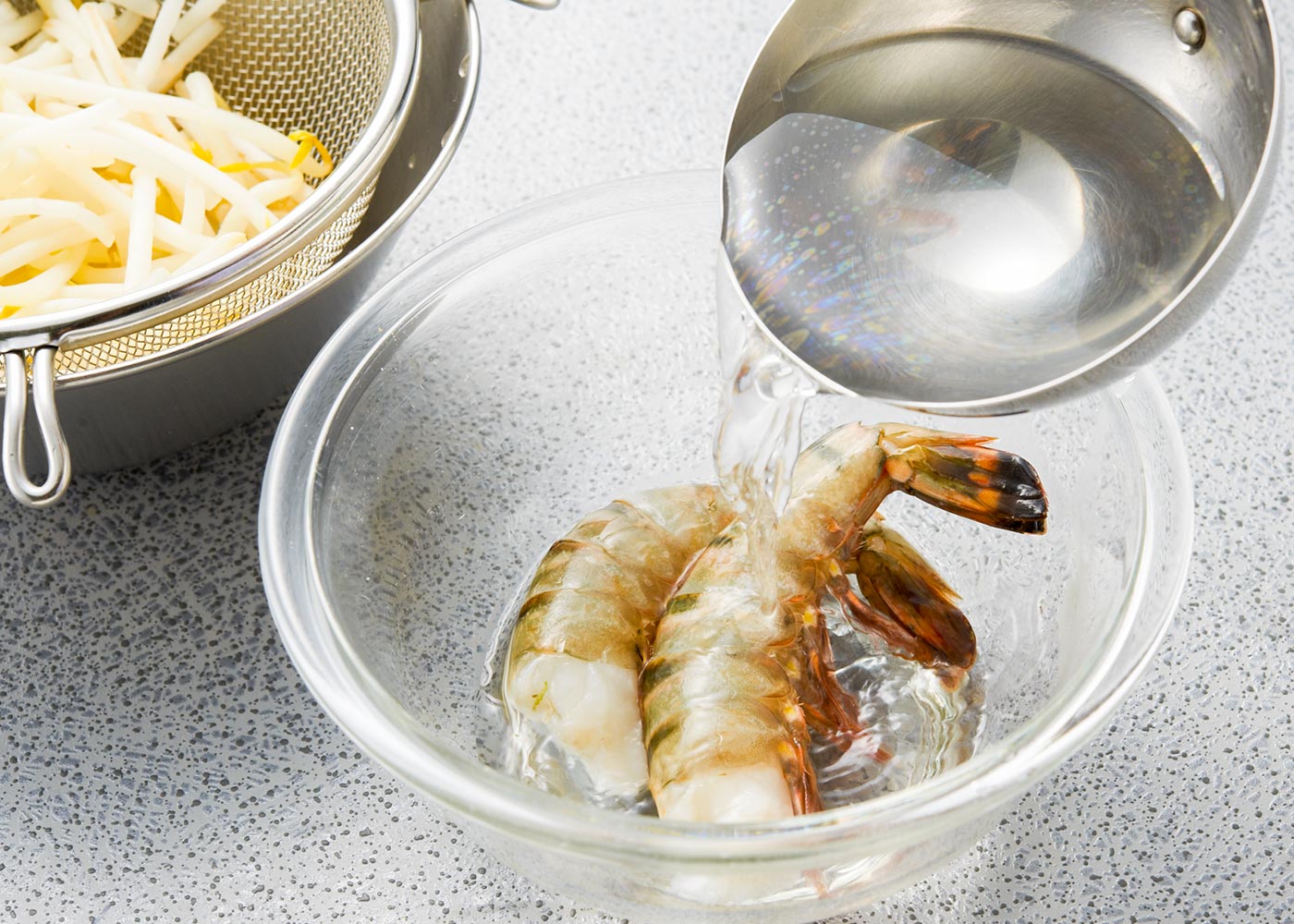 残りの湯1ℓを、えびに注ぎ、真っ赤になったら水に移し、殻をむき、2枚にそぐ。